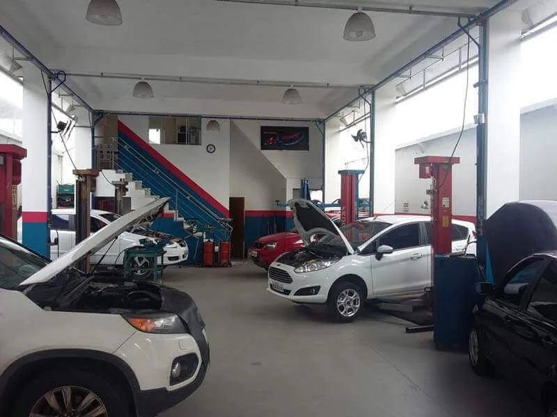 Interior da oficina da Vinik's com vários veículos em manutenção